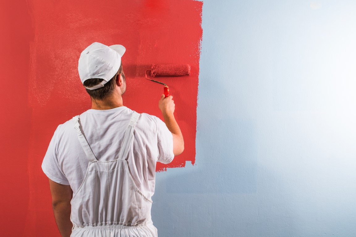 Man painting wall with roller